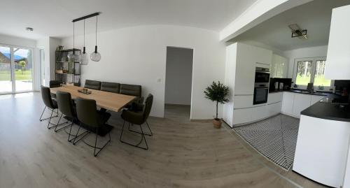 a kitchen and dining room with a table and chairs at Ferienhaus Zörweg - Feels like home in Matzling
