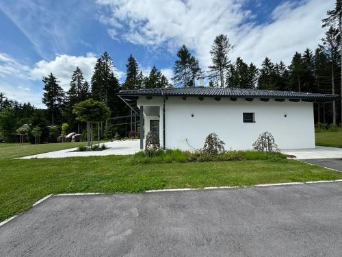 a white building with a parking lot in front at Ferienhaus Zörweg - Feels like home in Matzling