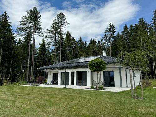 a small white house with a large yard at Ferienhaus Zörweg - Feels like home in Matzling