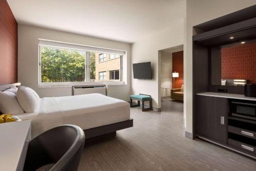 a hotel room with a bed and a window at The Orbit Hotel, Trademark Collection by Wyndham in Fairview Park