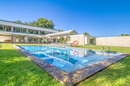 a swimming pool in front of a building at Quinta Do Pomar Pomar Farm in Linhares