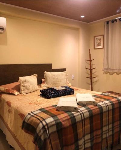 a bedroom with a large bed with a plaid blanket at Nega Joana in Araruna