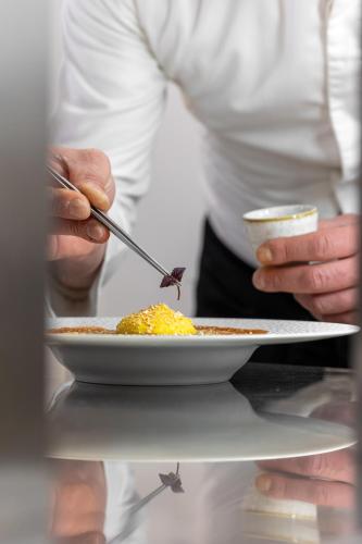 a person holding a plate of food with a spoon at Hotel Vannucci in Città della Pieve
