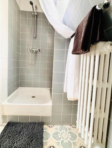 une salle de bain avec douche et baignoire blanche dans l'établissement Cosy Place entre l'Arc de Triomphe et les Champs-Élysées, à Paris