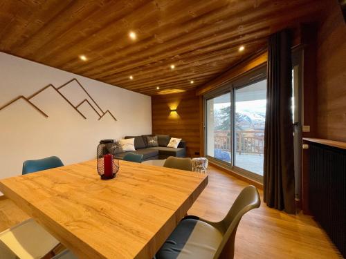 une salle à manger avec une table et des chaises en bois dans l'établissement Homency - Résidence Azur A1, à L'Alpe-d'Huez