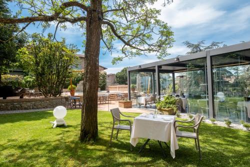 a table and chairs in a yard with a tree at Hotel Vannucci in Citt&agrave; della Pieve