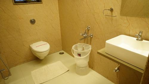 a bathroom with a toilet and a sink at Hotel Ganpati Palace Shirdi Newly Renovated in Shirdi