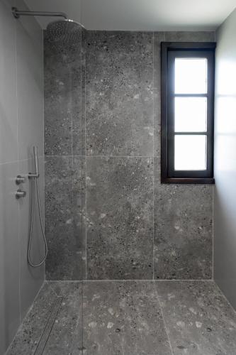 a bathroom with a glass shower with a window at Kenta Mountain Hotel & Gastrobar in Portariá