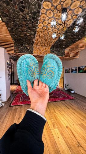 a person holding a blue heart in a room at Kezgin Guest House in Naryn