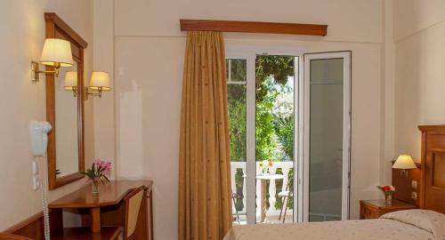 a bedroom with a bed and a sliding glass door at Kerveli Village Hotel in Kerveli