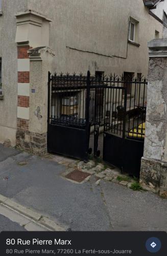 une porte en fer noir devant un bâtiment dans l'établissement Le Cocon Douillet - 5