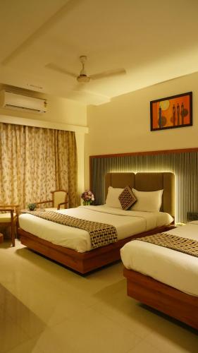 Postel nebo postele na pokoji v ubytování Hotel Ganpati Palace Shirdi Newly Renovated