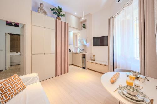 a living room with a table and a kitchen at Little Bangkok - Luxury SPA Apartment in Toulon