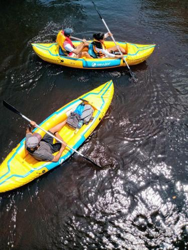 three people are in kayaks in the water at Casa Morada dos Pássaros - 3 suítes in Imbassai