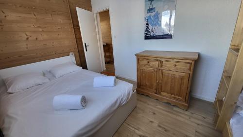 une chambre avec un lit avec deux serviettes dessus dans l'établissement Homency - Résidence Kandahar 10, à L'Alpe-d'Huez