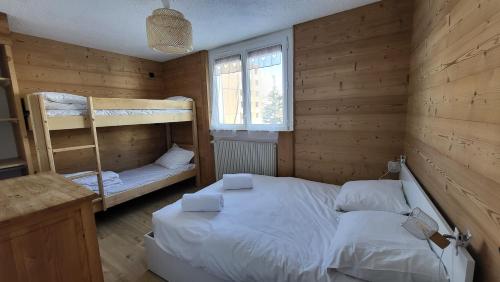 une chambre avec deux lits superposés et une fenêtre dans l'établissement Homency - Résidence Kandahar 10, à L'Alpe-d'Huez