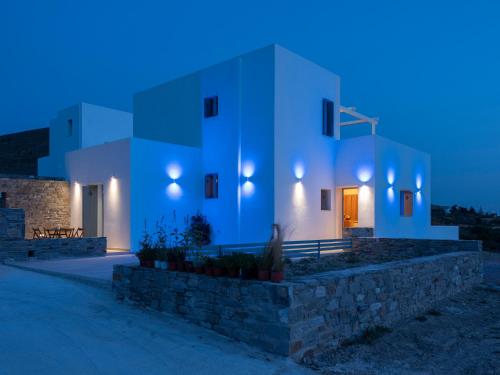 a white building with a stone wall in front of it at Galanos villa in Krotiri