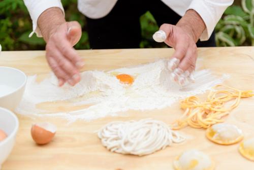 a person is preparing food on a cutting board at Hotel Vannucci in Città della Pieve