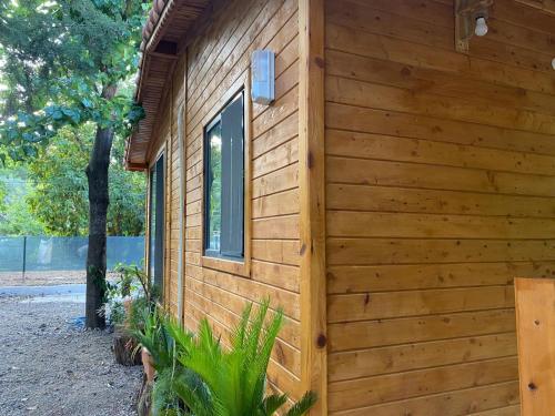 a wooden building with a window on the side at Canario Bungalows in Cıralı