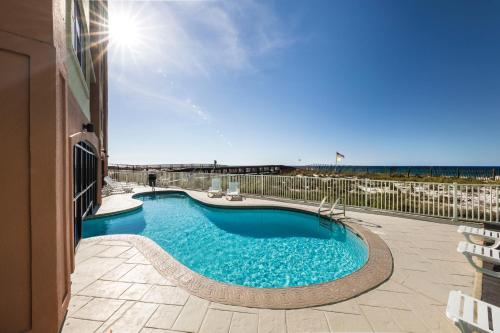 uma grande piscina com o oceano ao fundo em Harbor Place Condos em Gulf Shores