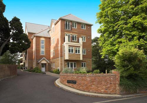 a large brick building with a driveway in front of it at Haven With Patio in Basingstoke