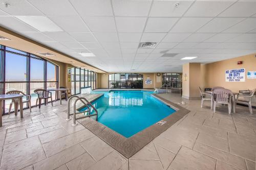 uma piscina com cadeiras e mesas num edifício em Harbor Place Condos em Gulf Shores