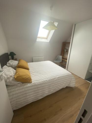 une chambre avec un lit avec des oreillers jaunes dessus dans l'établissement appartement Dinan, à Dinan