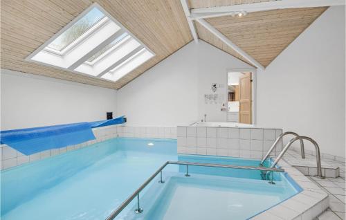 a large swimming pool with a skylight at Holiday Home Gøgevej Dronningmølle Xi in Dronningmølle