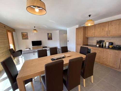 une salle à manger avec une table et des chaises en bois dans l'établissement Ferme de Suzanne 9, T4 avec vue surplombant la station - Multipass inclu, à Châtel