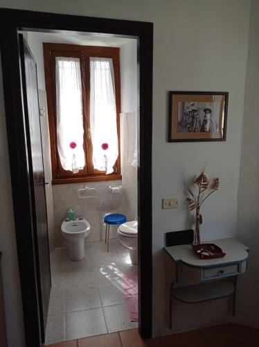 a bathroom with a toilet and a sink at Dulcius ex Asperis Bed & breakfast in Ponte Nizza