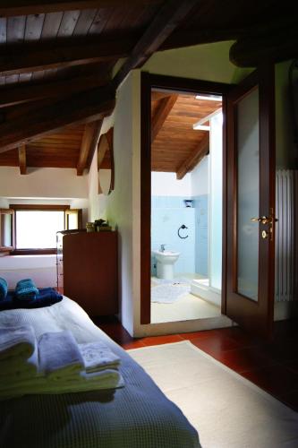 a bedroom with a bed and a bathroom with a toilet at Dulcius ex Asperis Bed & breakfast in Ponte Nizza