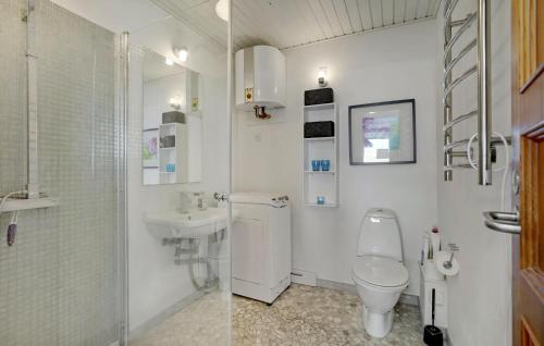 two pictures of a bathroom with a toilet and a sink at 2 Bedroom Nice Home In Roslev in Roslev