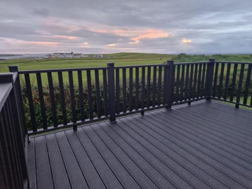 a wooden deck with a view of a green field at 9 Tullan Strand, Bundoran in Bundoran