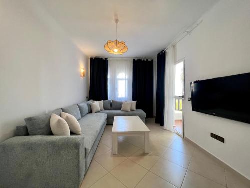 a living room with a couch and a flat screen tv at Blue Pearl Apartment in Cabo Negro
