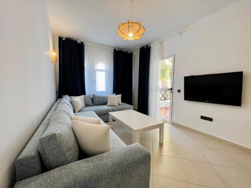 a living room with a couch and a tv at Blue Pearl Apartment in Cabo Negro