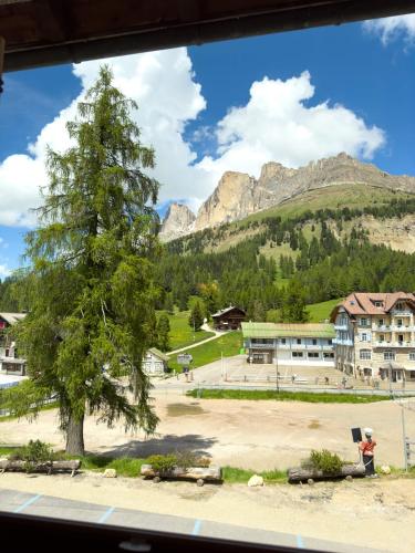 a view from a window of a building with a tree and mountains at Bar-Restaurant-Pizzeria Antermont B&B in Carezza al Lago