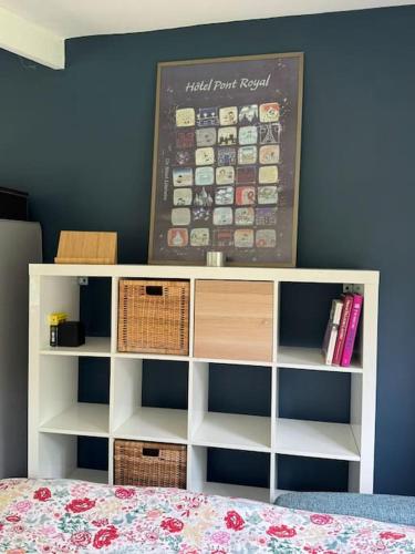 a bedroom with a bed and a white book shelf at Grand studio neuf sur jardin privé a 35 mn du RER A Charles de Gaulle Etoile in Maisons-Laffitte