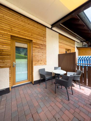 a patio with chairs and a table on a brick patio at Bar-Restaurant-Pizzeria Antermont B&B in Carezza al Lago