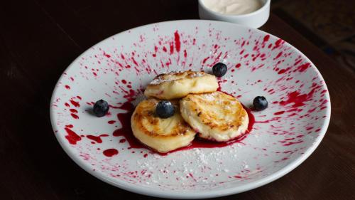 een bord met eten, met bananen en bosbessen erop bij Palmira Hotel in Yelizavetovka