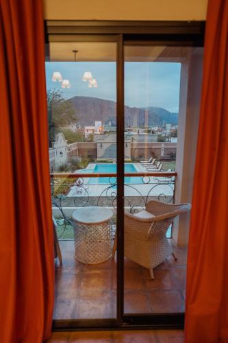 a room with a balcony with a view of a pool at Luna de Cafayate Hotel Boutique in Cafayate