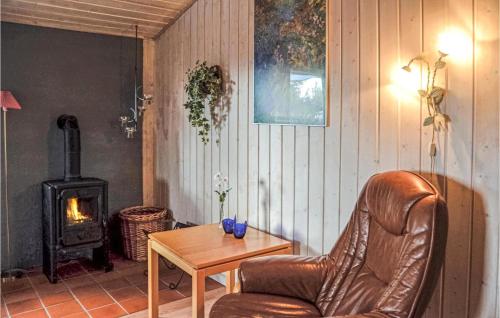 a living room with a leather chair and a wood stove at 4 Bedroom Stunning Home In Thisted in Thisted