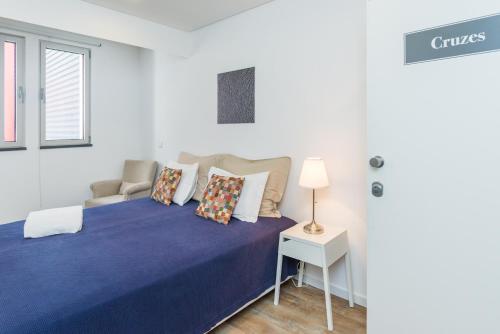 a bedroom with a blue bed with a chair and a table at Casa da Praça Double room - by Casas na Ilha in Funchal