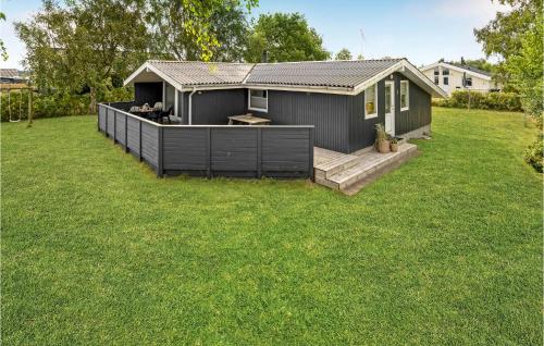 a small house with a deck in a yard at 3 Bedroom Awesome Home In Børkop in Børkop