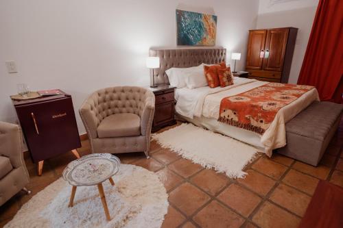 a bedroom with a bed and a chair and a couch at Luna de Cafayate Hotel Boutique in Cafayate