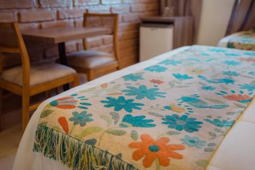 a bed with a blanket with flowers on it at Luna de Cafayate Hotel Boutique in Cafayate