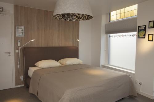 sypialnia z łóżkiem i dużym oknem w obiekcie Stadslogement Kingsize w mieście Sneek