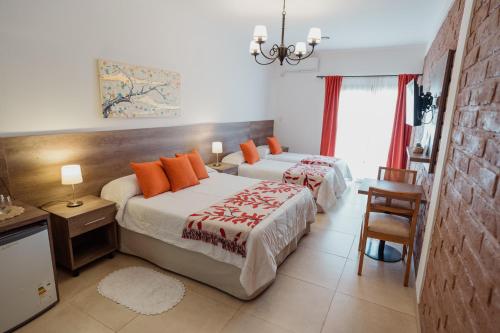 a bedroom with two beds with orange pillows at Luna de Cafayate Hotel Boutique in Cafayate