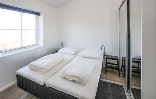 a white bedroom with two beds and a mirror at 3 Bedroom Gorgeous Home In Samsø in Toftebjerg