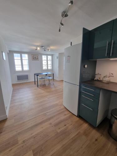 une cuisine avec un réfrigérateur blanc et une table dans l'établissement Beau 4 pièces au cœur de Paris, à Paris