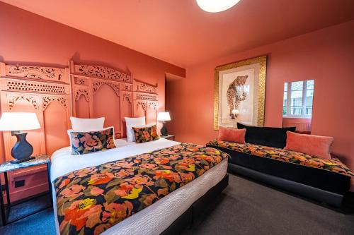 a bedroom with two beds and orange walls at Hotel Villa Nicolo - Tour Eiffel in Paris